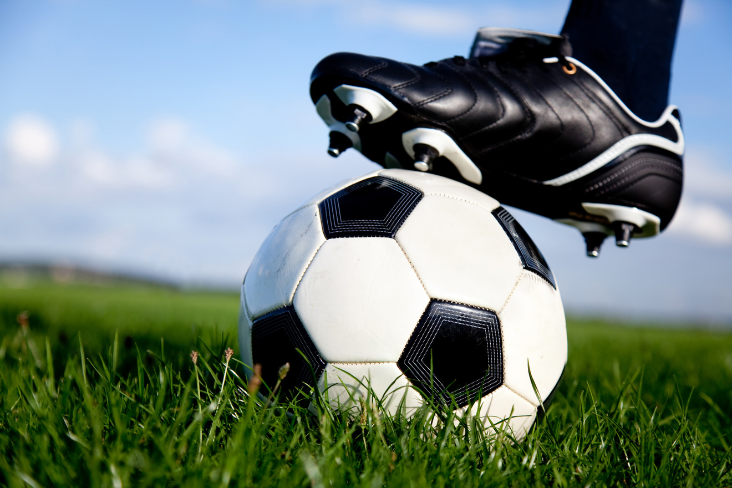 Football under a cleated foot